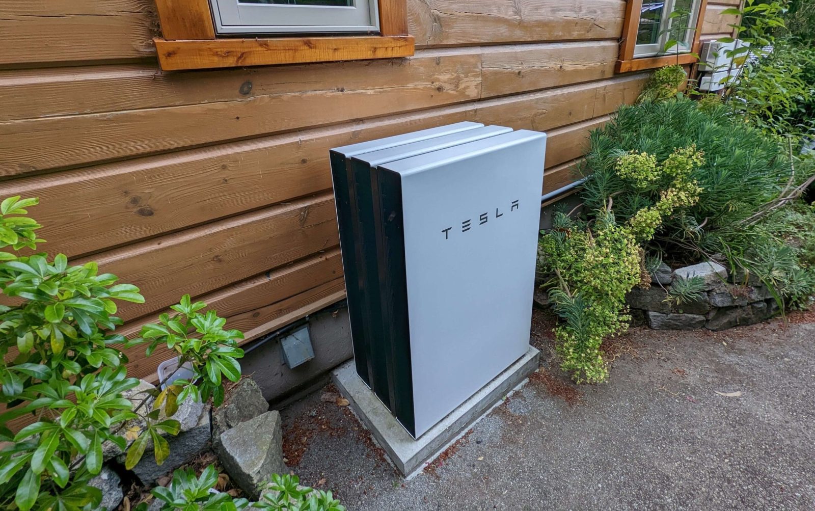 Tesla Powerwall installed along the side of a home.